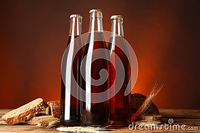 Bottles of delicious fresh kvass, spikelets and bread on wooden table Stock Photo