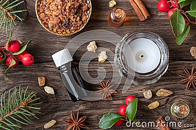 Bottles of essential oil on a Christmas background with frankincense, myrrh, wintergreen and winter spices Stock Photo