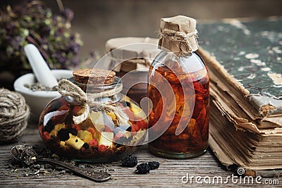 Bottles of essential oil or infusion, mortar and book. Herbal medicine Stock Photo