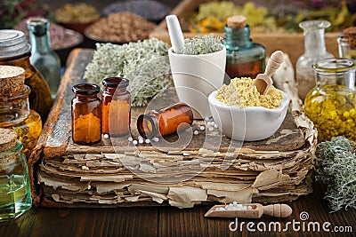 Bottles of homeopathic drugs, mortars of mineral substances and medicinal plants. Infusion bottles and healing herbs. Homeopathy Stock Photo