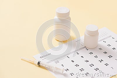 Bottles of medicines and syringe on a sheet of calendar Stock Photo