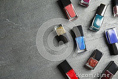 Bottles of nail polish on grey background, top view Stock Photo