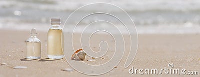 Bottles with oil essence and shell in the sea waves. Spa and wellness setting on sand and wave background. Manicure and Stock Photo