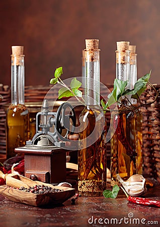 Bottles of olive oil with various spices and vintage cooking utensils Stock Photo