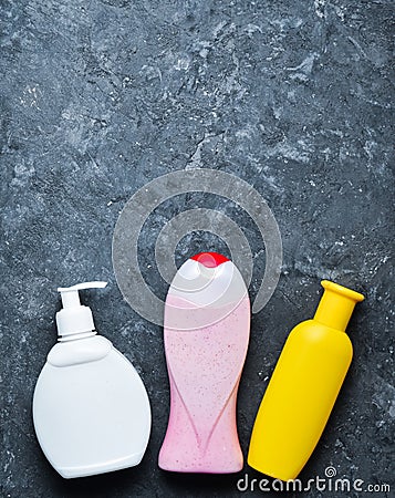 Bottles of products for showering on a black concrete surface. shampoo, soap, shower gel. Copy space. Top view. Flat lay Stock Photo