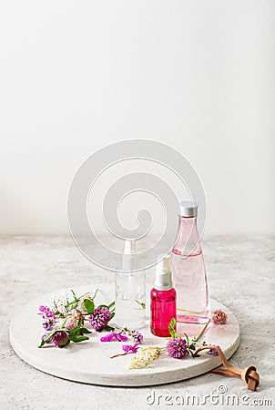 Bottles skincare lotion serum medical flowers herbs. natural cosmetic. clover milfoil tansy rosebay Stock Photo