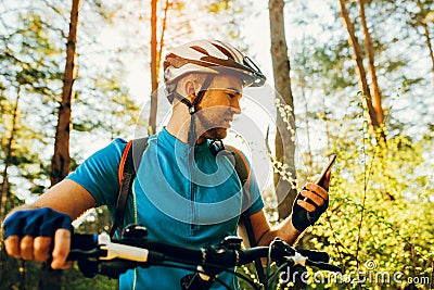 Bottom and side view of bicyclist on bike using navigator on smart phone, explore map and search GPS coordinates while biking in Stock Photo