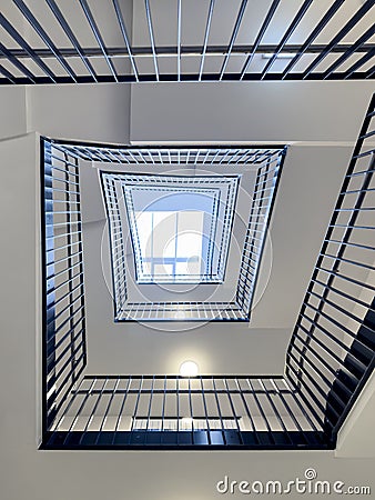 Bottom-up view of rectangular spiral staircase in modern multi-storey residential Stock Photo