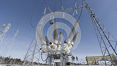 Bottom view of electricity grid and transformer on blue cloudy sky background. Action. Power line at the electricity Stock Photo