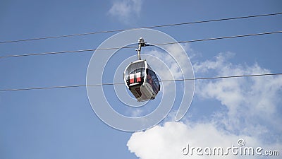 Bottom view of the funicular cable railway, cabins moving on blue cloudy sky background. Action. New cabins moving Editorial Stock Photo