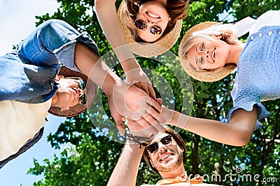 bottom view of multiethnic smiling friends holding Stock Photo