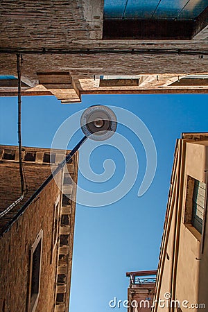 Bottom view of Traditional street lamp at an old Venetian housein the middle of the day with a blue sky Stock Photo