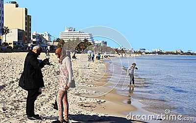 Boujaafar beach in winter with blue skies and sunshine with an elderly Tunisian couple in the foreground Editorial Stock Photo