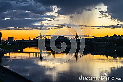 Mesmerizing blazing sunset over the mirror glossy surface of the Volga river, reflecting dramatic sky. City of Tver, Russia. Stock Photo