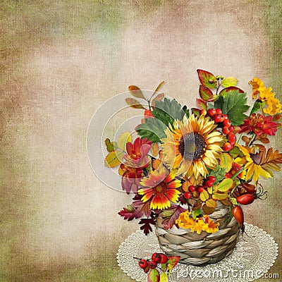 Bouquet of autumn flowers, leaves and berries in a wicker basket on a vintage background Stock Photo