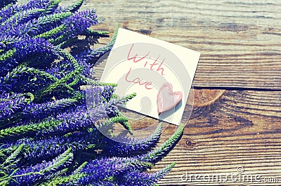 Bouquet of blue wild summer flowers,one decorative heart and the white card with the inscription With love Stock Photo