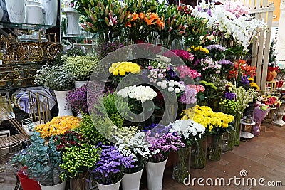 Bouquet of colorful roses and other different flowers at the entry to flower shop at farmers` market. Colorful peony, roses etc. Editorial Stock Photo