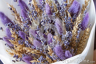 Bouquet of dried flowers in the hands of a florist girl lavender cereal on a gray background Stock Photo