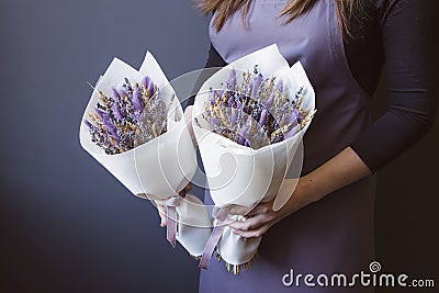 Bouquet of dried flowers in the hands of a florist girl lavender cereal on a gray background Stock Photo