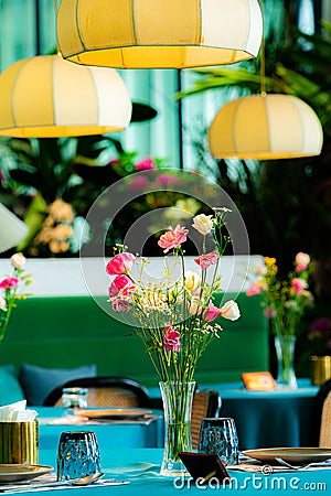 A bouquet of flowers in a vase on a table in the dining room. Stock Photo