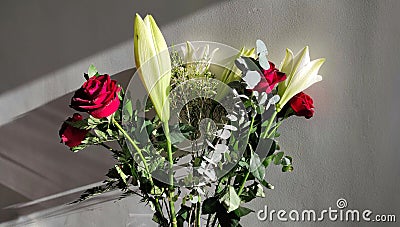 A bouquet of flowers with roses on a white background - light and shadows. Stock Photo