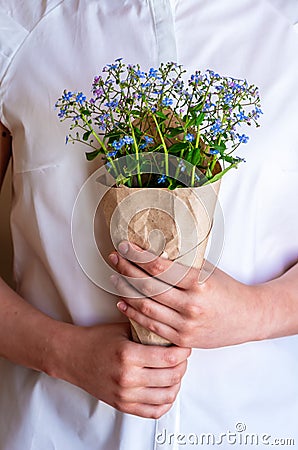 A bouquet of forget-me-nots in the hands of the girl, close-up Stock Photo
