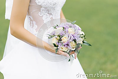 Bouquet of lilac eustoma and milk roses in the hands Stock Photo