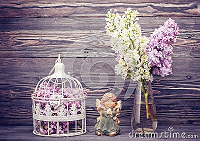 Bouquet lilac flowers, angel and bird cage. style nostalgia Stock Photo