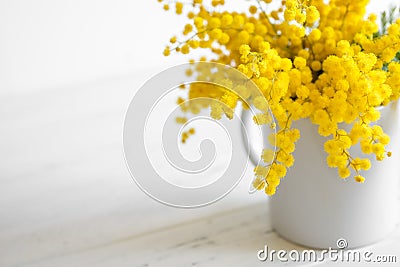 Bouquet of mimosa flowers on white wooden background. Springtime Stock Photo