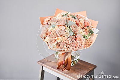 Bouquet Peach and orange color. Beautiful bunch mixed flowers in wooden table. the work of the florist at a flower shop Stock Photo