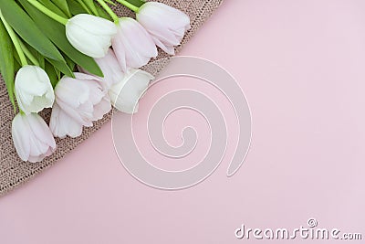 Bouquet of pink pastel tulips on pink knit sweater background, top view of pink tulips bouquet for womans Day, spring flowers Stock Photo