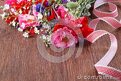 Bouquet of red and pink poppy and blue cornflower ley on brown wooden background. Stock Photo