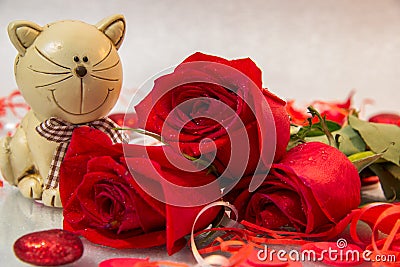 Bouquet of red roses with a cat figurine Stock Photo