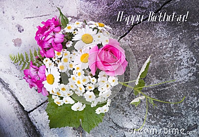 Bouquet of roses, geranium, daisies on a concrete wall with a crack Stock Photo