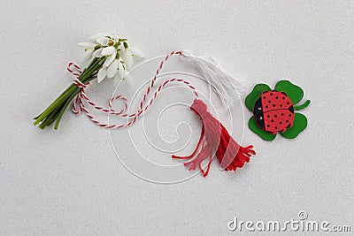 Bouquet of snowdrops on white background with red and white rope and lalybug. First of march celebration Martisor. Stock Photo