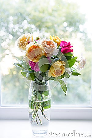 Bouquet of summer roses in glass vase near the window . flower background, greeting card Stock Photo