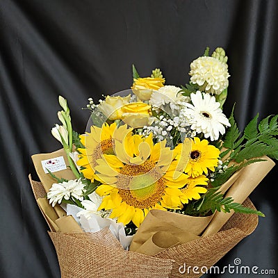 A bouquet with sunflowers, yellow roses, gerberas and another white flower Stock Photo