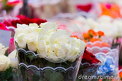 A bouquet of white roses on bright blurred background. Selling flowers at a street market Stock Photo