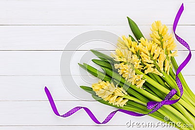 Bouquet of yellow hyacinths decorated with purple ribbon. Top view Stock Photo