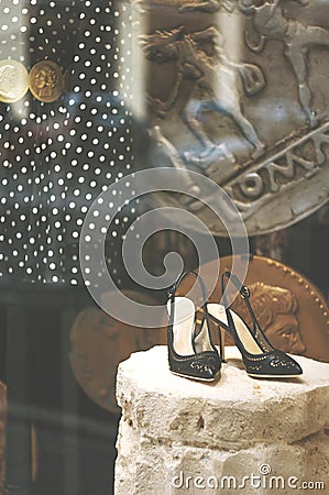 Boutique fashion display window with a dressed mannequin and black shoes in modern italian shop at the street of Florence city Editorial Stock Photo