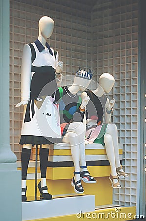 Boutique fashion display window with a dressed mannequin and bla Editorial Stock Photo