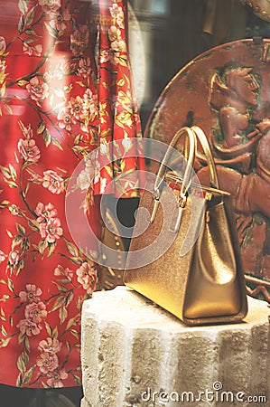 Boutique fashion display window with a dressed mannequin and golden bag in modern italian shop at the street of Florence city Editorial Stock Photo