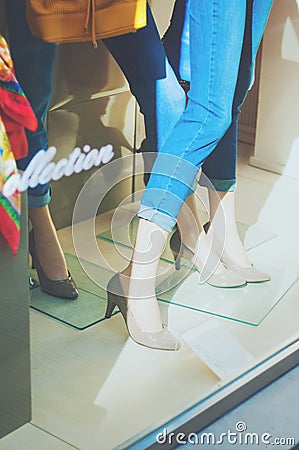 Boutique fashion display window with a legs and shoes of dressed Editorial Stock Photo