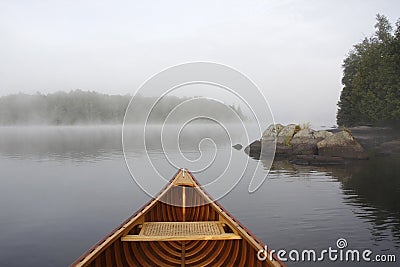 Bow of a Cedar Canoe on a Misty Lake Stock Photo