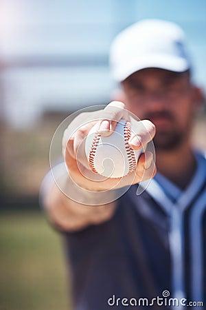 Bow down to the almighty baseball. a man holding a ball during a baseball match. Stock Photo
