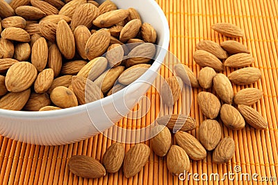 Bowl of almonds on rattan mat Stock Photo