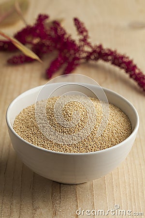 Bowl with amaranth seeds and a twig with flowers Stock Photo