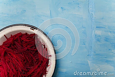 Bowl of beetroot cut into thin strips on blue painted wooden background. Vegetarian, organic, healthy food, diet, nutrition Stock Photo