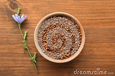 Bowl of chicory granules and flower on wooden table, flat lay Stock Photo