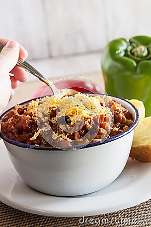 Bowl of Chili With Corn Bread Muffin Hand Scooping Stock Photo
